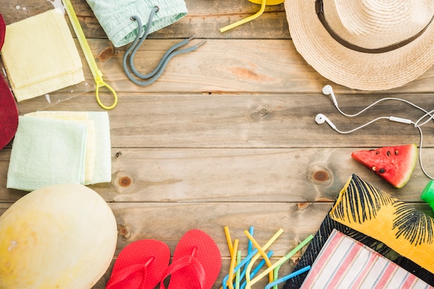 Hut nahe kopfhörer und flipflops mit früchten und vakuumbeutel Kostenlose Fotos
