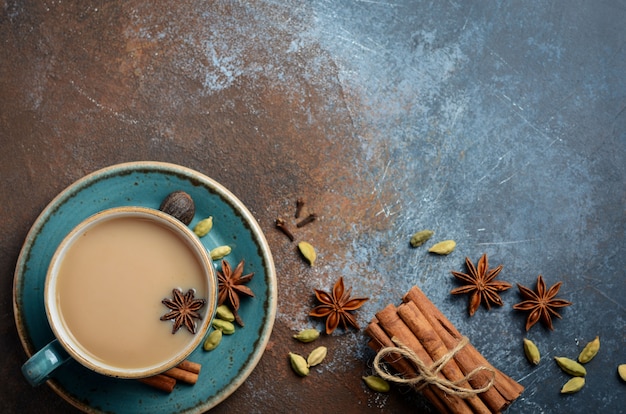 Indischer masala chai tee. gewürztee mit milch auf dunklem rostigem ...