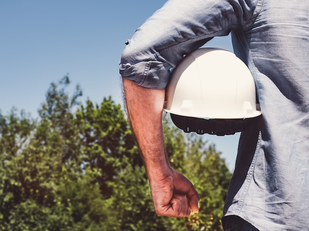 Ingenieur, weißen hardhat im park halten Premium Fotos