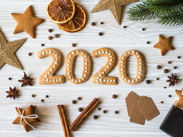 Ingwerkekse in form von zahlen und 2020 neues jahr ingwer kekse aus weißem holz. ansicht von oben. saisonale verpackung, gewürze und silvesterattribute Premium Fotos