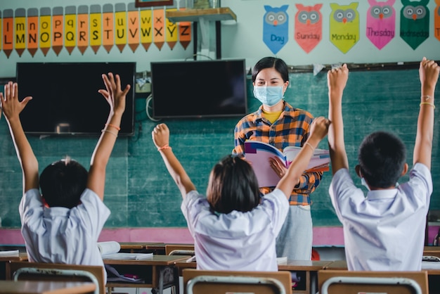 Junge Asiatische Lehrerin Mit Medizinischem Gesicht Und Schuler Einer Landlichen Thailandischen Dorfschule Lernen Premium Foto