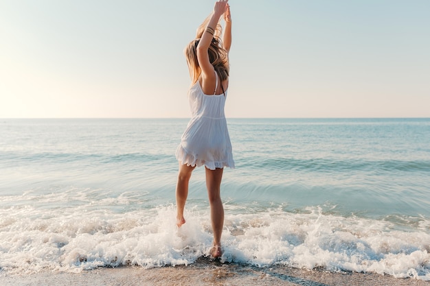 Junge Attraktive Gluckliche Frau Die Sich Am Sonnigen Sommermode Stil Des Seestrandes Im Urlaub Des Weissen Kleides Umdreht Kostenlose Foto