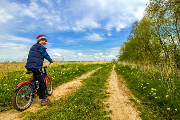 Junge auf fahrrad auf landstraße sonnigen frühlingstag