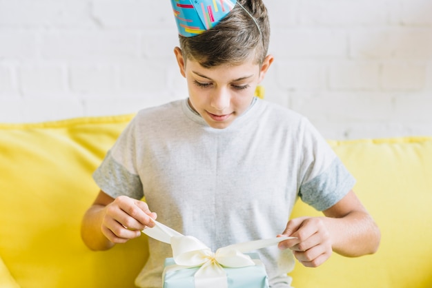 Junge, der geschenk während seines geburtstages auspackt Kostenlose Fotos