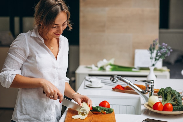 Junge frau an der küche frühstück kochend Kostenlose Fotos