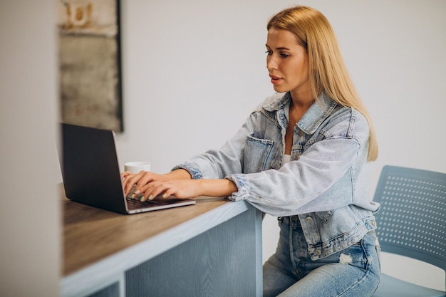 Junge frau, die am computer von zu hause aus arbeitet