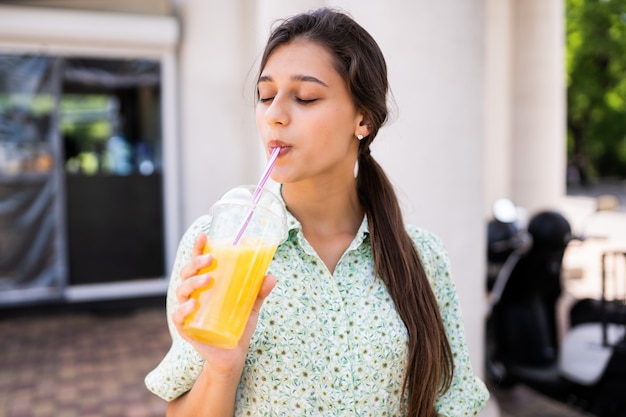 Junge Frau Lachelt Und Trinkt Cocktail Mit Eis Im Plastikbecher Mit Strohhalm Auf Stadtstrasse Kostenlose Foto