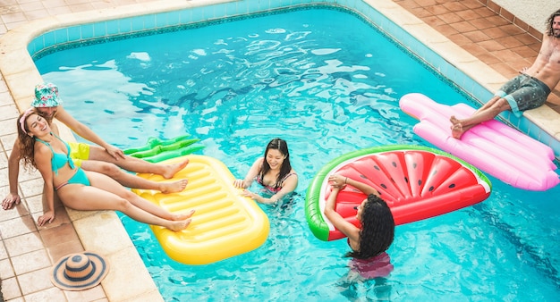 Junge Freunde Die Mit Luftlilien Im Schwimmbad Schwimmen Gluckliche Leute Die Spass In Den Sommerferienferien Haben Premium Foto