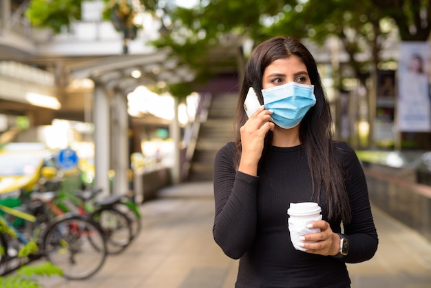 Junge Inderin Mit Maske Die Am Telefon Spricht Und Kaffee Unterwegs Als Neue Normalitat Wahrend Covid 19 Trinkt Premium Foto