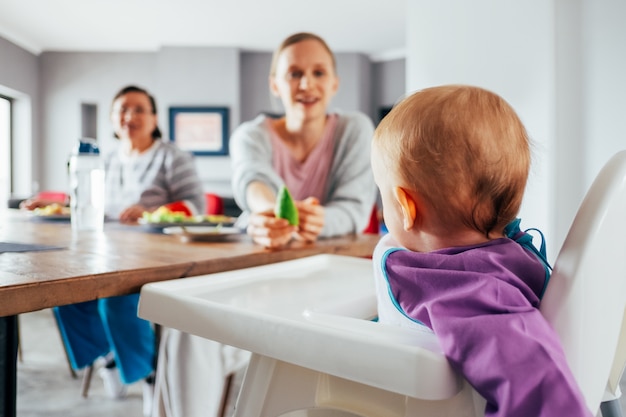 Junge Mutter Futtert Ihr Kind Mit Festem Essen Im Esszimmer Kostenlose Foto