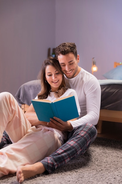 Junge paare, die zusammen im bett lesen Kostenlose Fotos