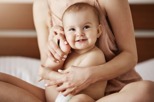 Junge Schone Gluckliche Mutter In Nachtwasche Und Ihr Neugeborenes Baby Sitzen Auf Dem Bett Lachelnd Zusammen Zu Hause Spielend Kostenlose Foto