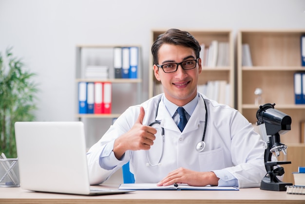 Junger erwachsener doktor mit laptop-computer Premium Fotos