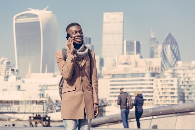 Junger mann, der auf mobile mit london-stadt spricht Premium Fotos