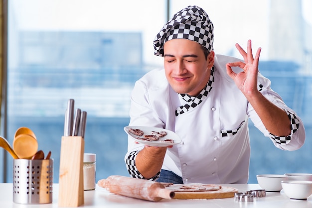 Junger mann, der plätzchen in der küche kocht Premium Fotos