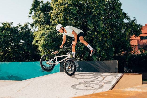 Junger mann, der tricks mit bmxfahrrad tut Kostenlose Foto