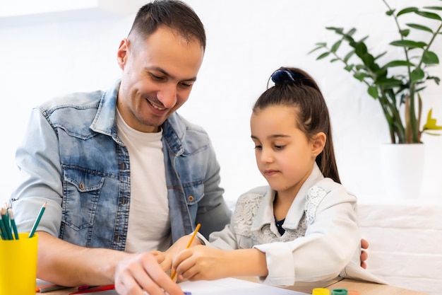 Junger vater hilft ihrer tochter bei ihrem schulprojekt