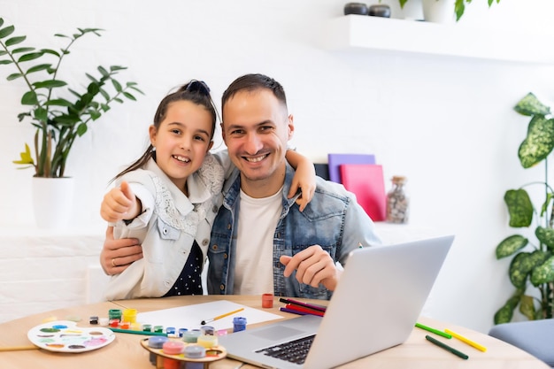 Junger vater hilft ihrer tochter bei ihrem schulprojekt