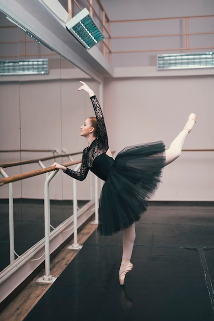 Junger weiblicher tänzer des klassischen balletts übend im tanzstudio Kostenlose Fotos