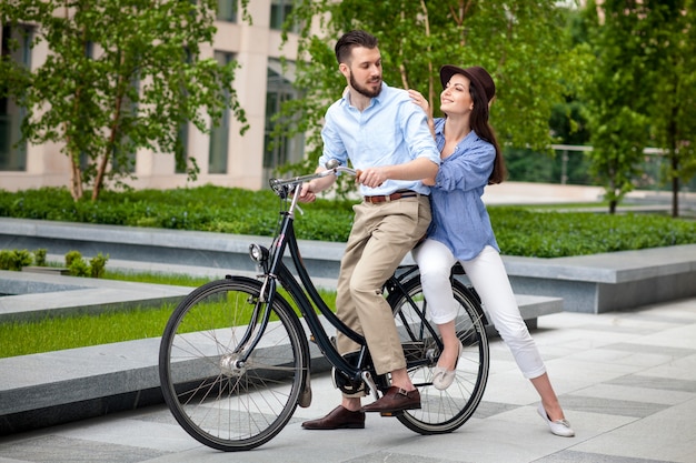 Junges paar, das auf einem fahrrad sitzt Kostenlose Foto