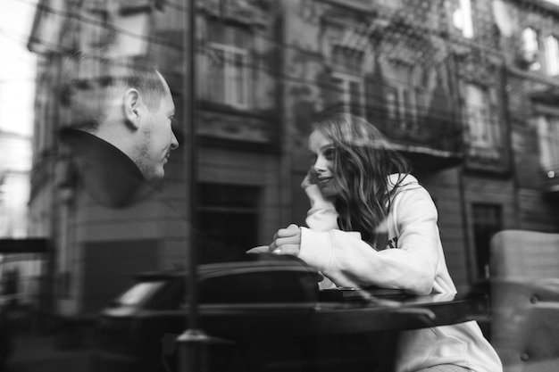 Junges Paar Sitzt In Einem Cafe Hinter Dem Fenster Kostenlose Foto