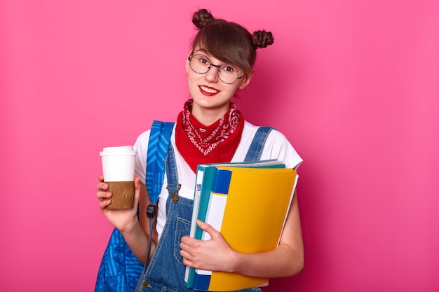 Junges Schlankes Brunettes Madchen Im Weissen Lassigen T Shirt Overalls Und Kopftuch Am Hals Tasse Kaffee Und Ordner Mit Dokumenten Haltend Isoliert Uber Rosig Posierend Youngster Konzept Kostenlose Foto