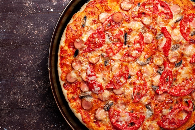 Käsige tomatenpizza von oben aus der nähe mit oliven und würstchen in