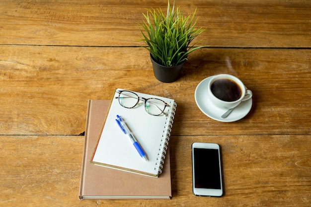 Kaffee oben und notizbuch, stift mit gläsern, handy auf ...