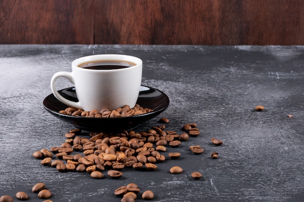 Kaffeetasse Mit Kaffeebohnen Auf Dunkler Tabelle Kostenlose Foto