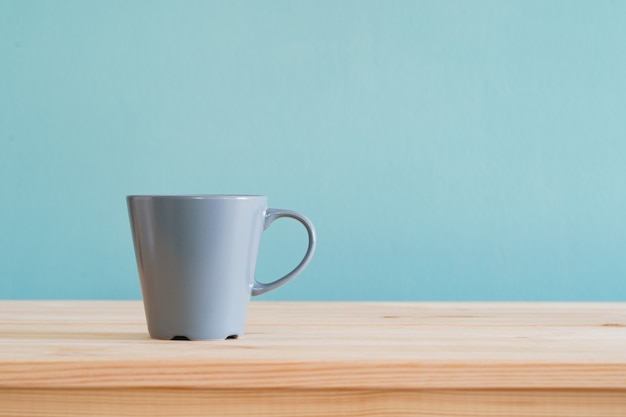 Kaffeetassen Stellen Auf Braunen Holzschreibtisch Und Blaue Tapete Premium Foto