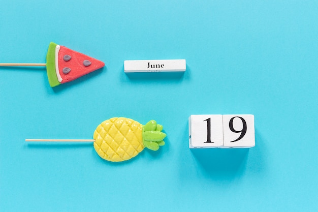 Kalenderdatum 19. juni und sommerfrüchte süßigkeiten ananas, wassermelonen lutscher. Premium Fotos