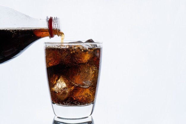Kaltes Trinken Giessen Von Soda Aus Der Flasche Glas Cola Mit Eis Fur Heisses Und Sommergetrank Isoliert Auf Weisser Wand Premium Foto