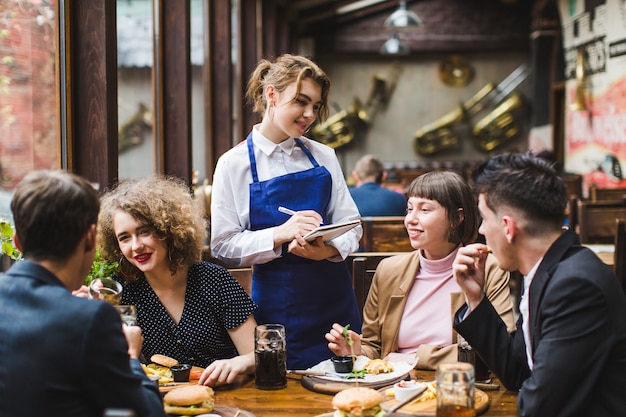 Kellnerin Die Bestellungen Von Leuten Im Restaurant Entgegennimmt Premium Foto