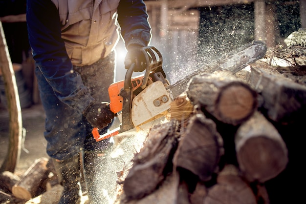 Kettensäge in aktion holz schneiden. mann, der holz mit säge, staub und