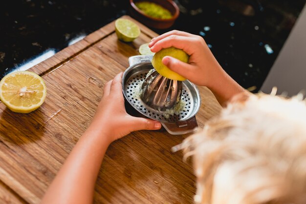 Kind, das den saft einer zitrone zusammendrückt. Premium Fotos