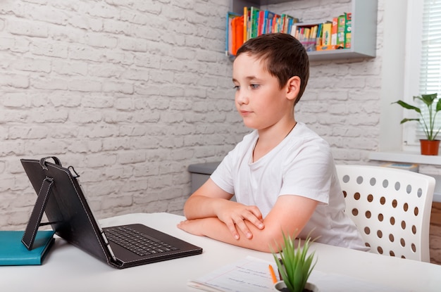 Kind mit tabletlernen zu hause. junge, der die ideen aus