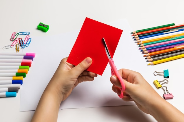 Kinderhande Die Ein Rotes Herz Aus Papier Schneiden Premium Foto