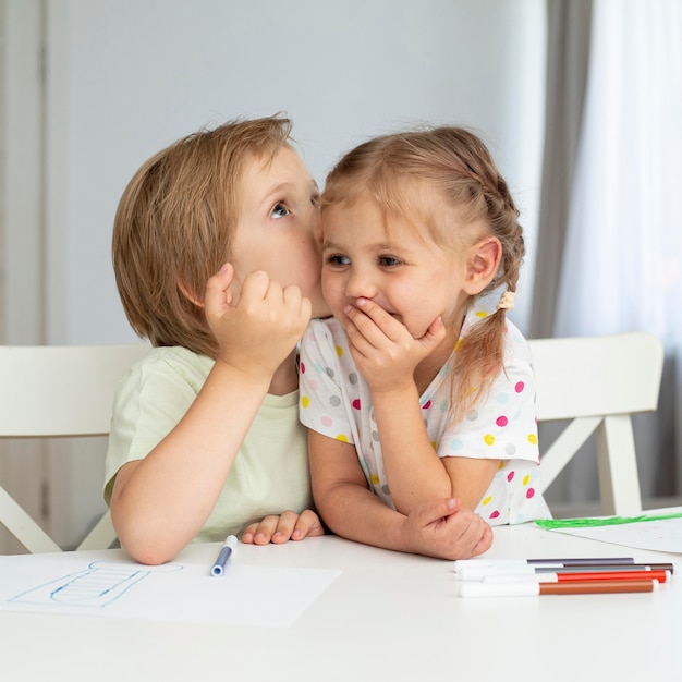 Kleine kinder, die zu hause zeichnen Kostenlose Foto