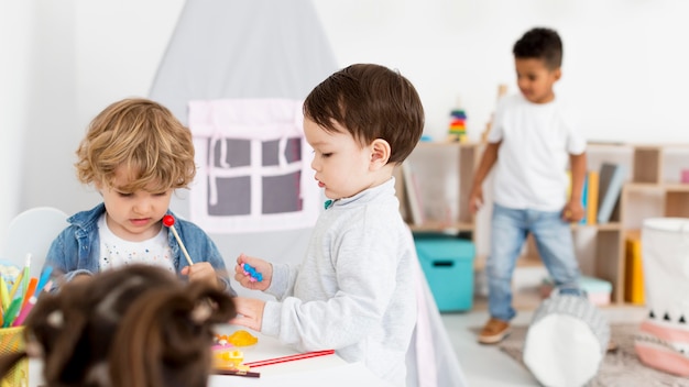 Kleine kinder, die zu hause zusammen spielen Kostenlose Foto