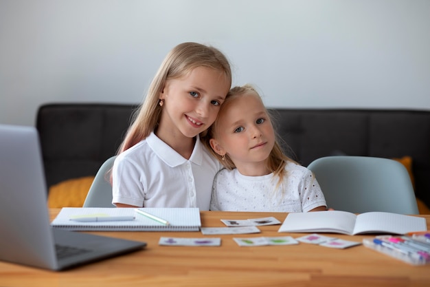 Kleine mädchen, die zu hause zusammen onlineschule machen