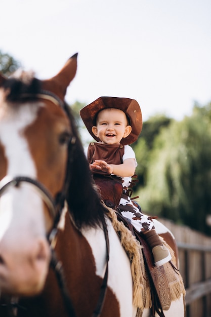 Kleiner Cowboy Der Auf Einem Pferd Sitzt Kostenlose Foto