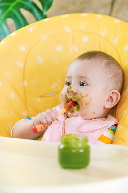 Kleines baby isst brokkoli-gemüsepüree. selektiver fokus. menschen ...
