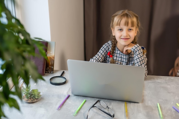 Kleines blondes mädchen, das zu hause am tisch