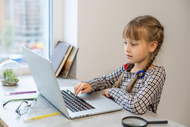 Kleines blondes mädchen, das zu hause am tisch