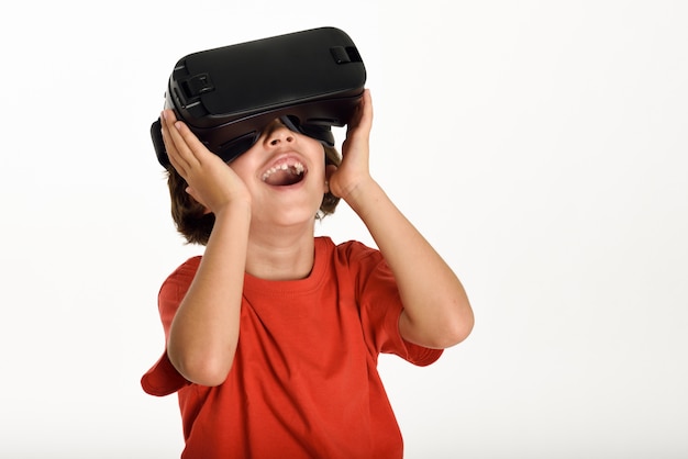 Kleines Mädchen schaut in VR Brille und Gestikulieren mit den Händen ...