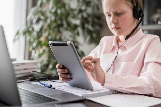 Kleines mädchen, das an onlineklasse zu hause teilnimmt