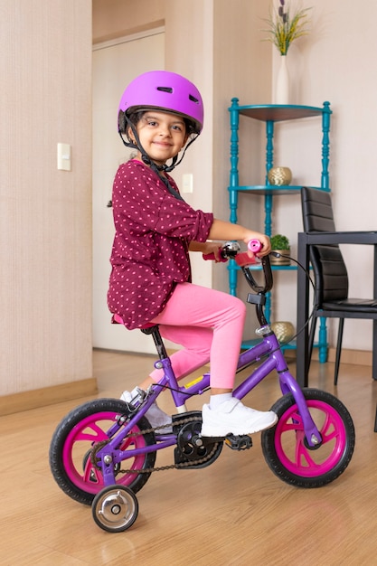 Kleines mädchen mit fahrradhelm glücklich, ihr fahrrad zu