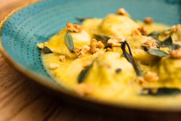 Köstliche platte von gekochten ravioliteigwaren auf holztisch Kostenlose Fotos