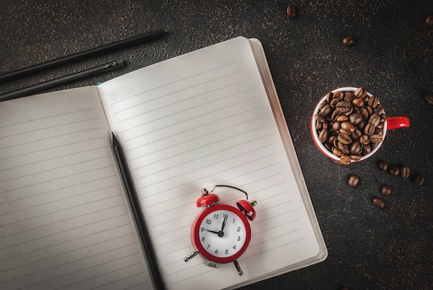 Konzept Eines Frohlichen Guten Starts In Den Arbeitstag Morgenkaffee Dunkler Rostiger Hintergrund Mit Kaffeebohnen Wecker Notizblock Und Einem Tasse Kaffee Draufsichtkopienraum Premium Foto