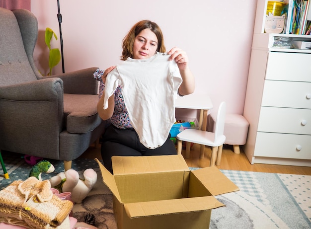 Konzept für die spende von winterkleidung für babys. frau